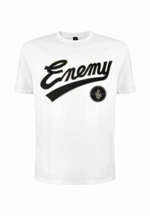 Camiseta blanca de manga corta con texto cursivo negro "Enemy" y un símbolo de objetivo con la silueta de una persona en el interior en el frente.