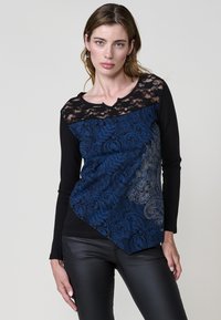 T-shirt à manches longues avec une partie supérieure en dentelle noire et une partie inférieure bleue à motif avec un design cachemire et des accents de boutons.