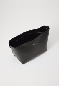 Zwarte leren tote bag met een gladde textuur, open top en zilveren hardware accenten. Heeft een logo dat aan de zijkant is gedrukt.
