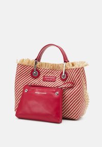 Wovenowa torba na ramię w czerwono-kremowe paski z frędzlami, z czerwonymi skórzanymi akcentami i odpinaną czerwoną kieszonką. Zawiera także srebrne elementy wykończeniowe.