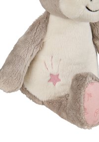 Soft plush toy with beige and cream fur. Features a pink star embroidery and paw print detail on the side. Round face with stitched smile.