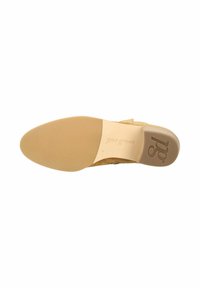 Zapato de ante beige con una puntera lisa y redondeada, y una plantilla de cuero; cuenta con una suela baja y plana de goma con el logo "paul green" en relieve.