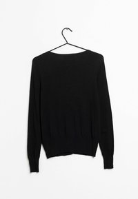 Svart stickad tröja med långa ärmar, rund halsringning och ribbad nederkant. Hänger på en svart metallgalge mot en vit bakgrund.