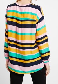 Gestreiftes Hemd in mehreren Farben mit horizontalen Bändern in Marineblau, Gelb, Pink, Grün und Türkis; lange Ärmel und abgerundeter Saum.