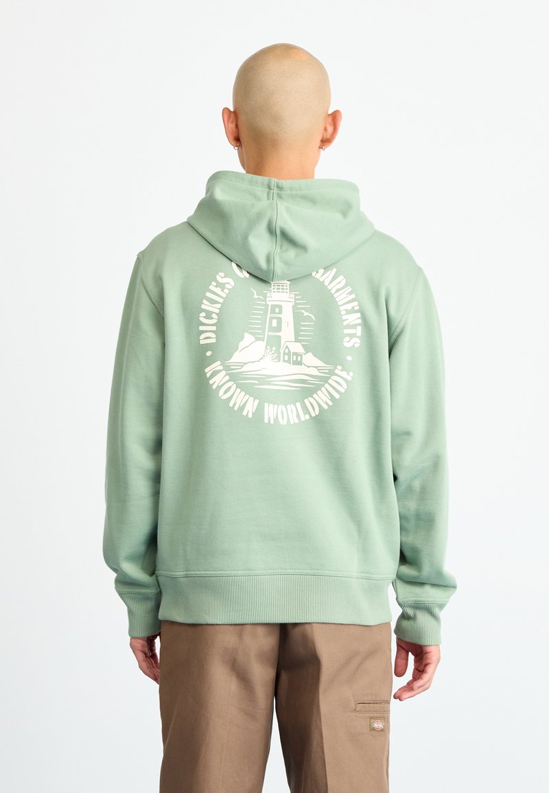 Green hooded sweatshirt featuring a lighthouse graphic on the back, ribbed cuffs and hem, soft texture, and relaxed fit.
