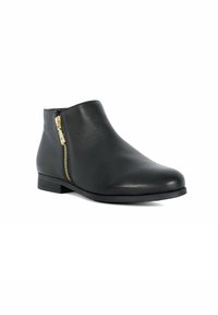 Bottine noire en cuir lisse avec un bout arrondi, fermeture éclair latérale accentuée par des détails en or, et une semelle en caoutchouc plate.