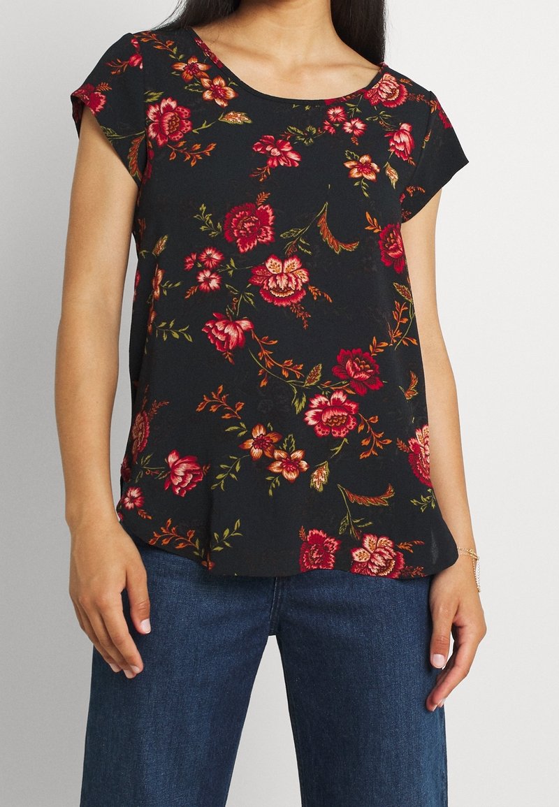 Haut noir à motif floral avec manches courtes, encolure arrondie et coupe ample. Le design comprend des roses rouges et orange vibrantes sur un fond sombre.