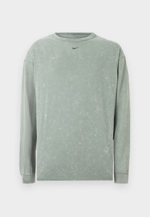 Dlhý rukáv, svetlozelený sveter z jemnej, textúrovanej látky. Obsahuje jemný vyblednutý vzor a malú tmavozelenú Nike logo na hrudi.