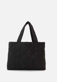 Black quilted tote bag with two sturdy fabric handles. Features diamond-shaped stitching and a rectangular label on one side.