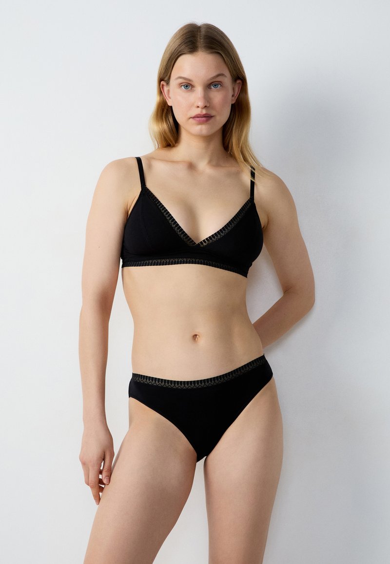 Schwarzes Bikini-Set mit einem dreieckigen Bralette mit zartem Besatz und passenden Bikinihosen mit niedriger Taille, gefertigt aus weichem, dehnbarem Stoff.