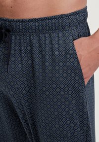 Donkerblauwe pantalons met geometrische patronen. Gemaakt van zachte stof, met een elastische tailleband en zijzakken voor extra gemak.