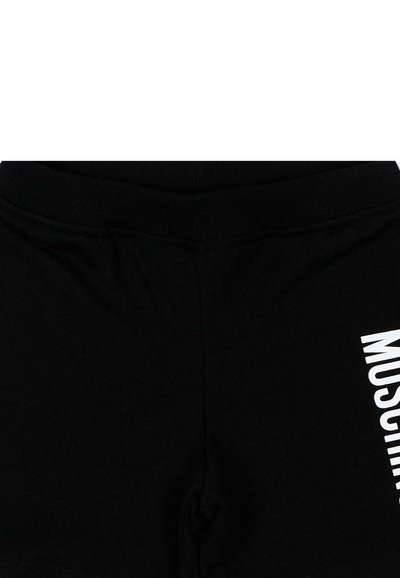 Shorts noirs avec une ceinture élastique et le texte vertical blanc "MOSCHINO" sur la cuisse droite.