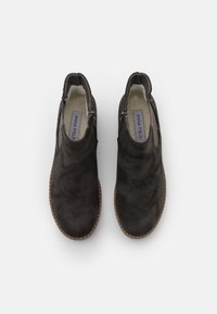 Para ciemnoszarych zamszowych botków za kostkę z bocznymi zamkami, pluszowym wnętrzem i brązowymi szytymi podeszwami, widziana z góry na białym tle.