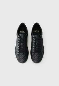Baskets noires avec un motif de logo sur l'ensemble, texture en cuir lisse, bout rond et lacets plats, avec un logo sur les semelles intérieures.