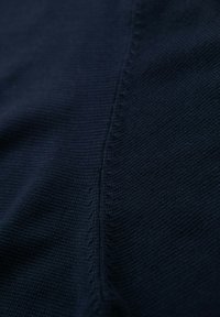 Marineblaue Strickware mit feiner Textur, die auf einer Seite über eine dezente Nahtdetails und eine gleichmäßige, glatte Oberfläche verfügt.