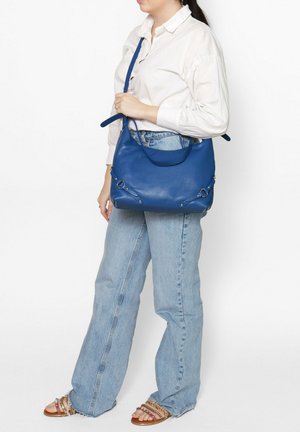 Blauwe leren schoudertas met een soepele textuur, gebogen bovenkant en decoratieve metalen accenten aan de zijkanten. Verstelbare schouderband voor veelzijdig gebruik.