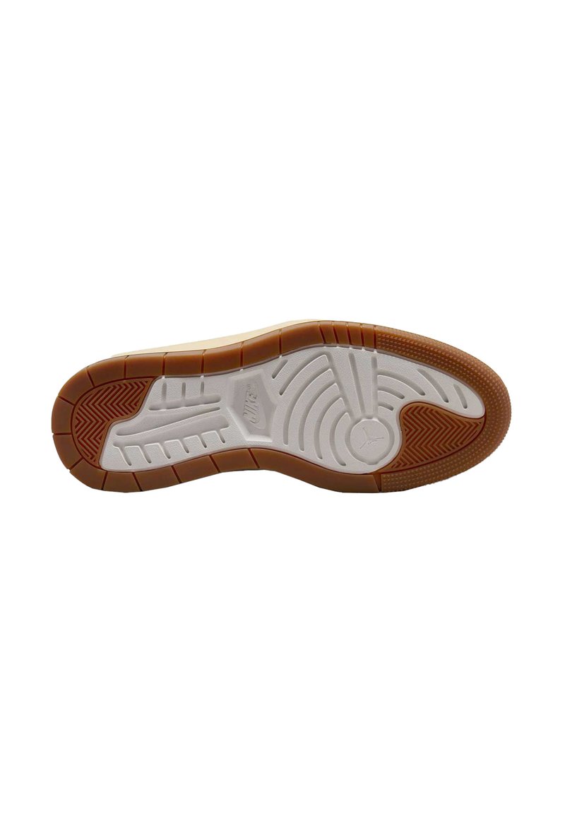 Semelle en caoutchouc blanche avec une zone de prise texturée en brun. Présente des motifs en relief et le logo "Nike" dans un design circulaire. Bords solides.