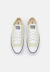 Baskets en toile vert clair avec lacets blancs, dotées d'un embout en caoutchouc et d'une bande noire le long de la semelle. Design classique avec logo sur la languette.