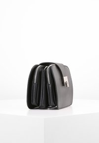 Strukturovaná kabelka kombinující šedou texturovanou kůži a černou hladkou kůži, doplněná o stříbrné kování a zipy.