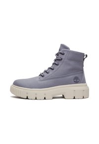 Botas de tobillo de lona gris con un acabado texturizado, suela de goma blanca y seis ojetes para los cordones. Presenta un logo de la marca en el costado.