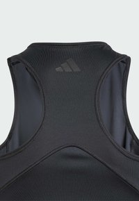Svart athletic linne med rund halsringning, ärmlös design och texturerad tyg. Har en subtil Adidas-logotyp i mitten bak.