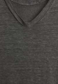 T-shirt grigio scuro a V in un tessuto morbido e testurizzato, con leggere variazioni di colore e una finitura del colletto liscia.