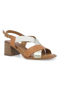 Sandal in pelle marrone e metallica con design incrociato, punta aperta e tacco medio. Presenta una cinghia alla caviglia regolabile e una texture liscia.