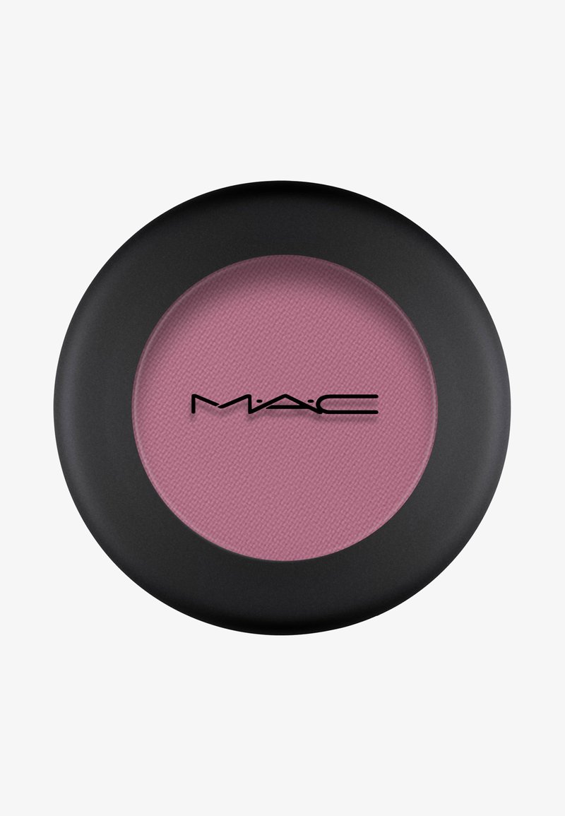Compact de blush rond avec un extérieur noir mat. Contient une poudre rose douce à l'intérieur, avec une surface texturée et un logo de la marque.