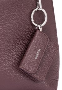 Burgundy leather handbag with a textured finish. Features a silver keychain and a matching cardholder attached. Logo displayed on cardholder.