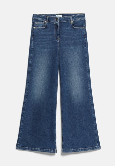 Jean bleu à jambes larges avec poches avant et arrière, passants de ceinture et fermeture à bouton et zip, étalé à plat sur un fond blanc.