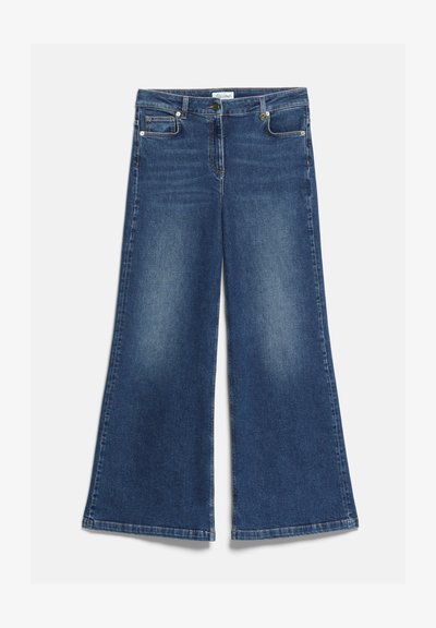 Jean bleu à jambes larges avec poches avant et arrière, passants de ceinture et fermeture à bouton et zip, étalé à plat sur un fond blanc.
