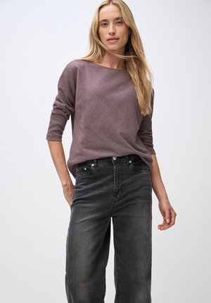 Haut texturé bordeaux à manches longues avec un décolleté large, associé à un jean noir à jambes larges avec poches avant et fermeture à bouton.