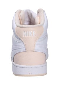 Sneaker mi-haut blanc avec des accents en cuir rose, col rembourré et languette texturée. Arbore un logo de marque blanc bien en vue sur le talon.