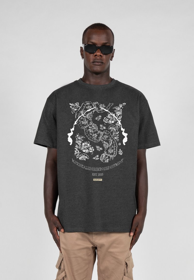 Dark gray T-shirt featuring a white floral and animal graphic print and a small logo tag at the bottom. Short sleeves, relaxed fit.