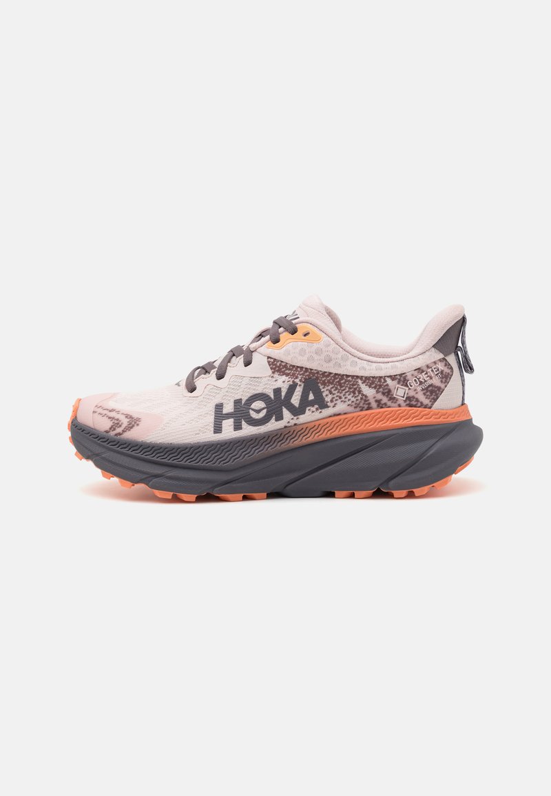 HOKA running shoes with a light pink mesh upper, gray accents, orange sole, and textured midsole. Features a lace closure and reinforced heel.