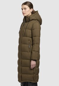 Oliven grøn lang puffjakke med hætte, udstyret med en kviltet design, lynlåslommer og justerbare snore i hætten.