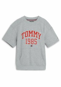 Felpa grigia oversize con maniche corte, caratterizzata dalla scritta "TOMMY 1985" in grassetto rosso. Include una tasca frontale e colletto a costine.
