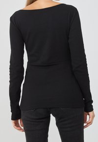 Zwarte top met lange mouwen van geribbelde stof met een brede halslijn. Het ontwerp heeft een nauwsluitende taille en een gladde, rekbare textuur.