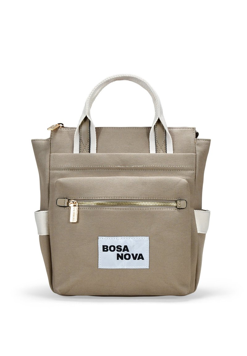 Mochila de lona beige con asas blancas, bolsillo frontal con cremallera y etiqueta "BOSA NOVA". Presenta un diseño estructurado y una textura duradera.