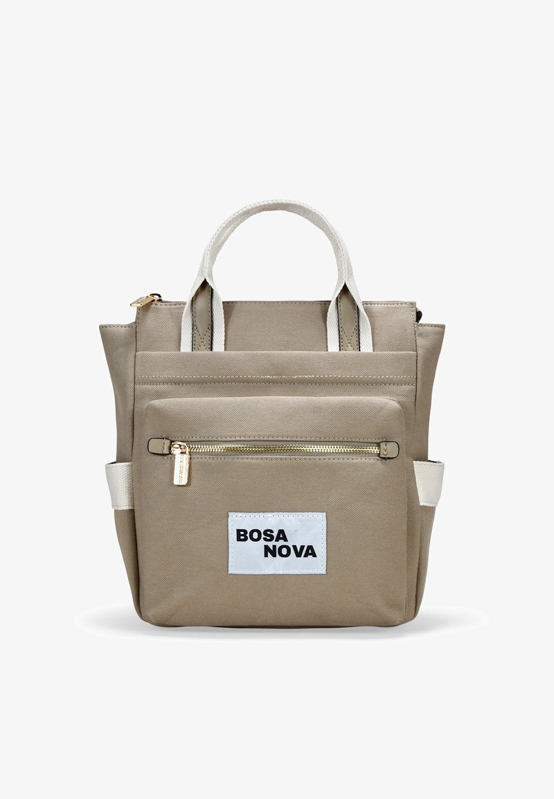 Mochila de lona beige con asas blancas, bolsillo frontal con cremallera y etiqueta "BOSA NOVA". Presenta un diseño estructurado y una textura duradera.