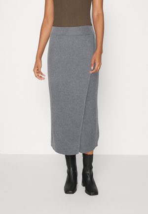 Jupe midi en tricot grise avec un design enveloppant, dotée d'une taille haute élastique et d'une texture lisse. Associée à de belles bottes noires hautes.