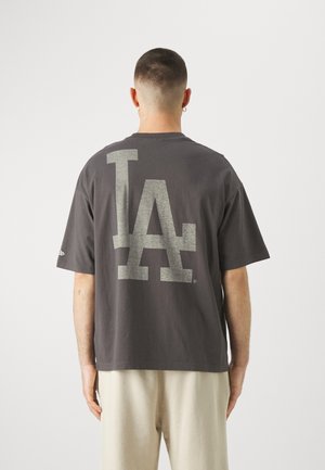 T-shirt en coton gris avec un grand motif "LA" clair au dos. Manches courtes et design décontracté.
