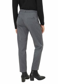Grijze gestreepte broek met een slim fit, voorzien van een soepele textuur, zijzakken en een gedefinieerde tailleband, gecombineerd met zwarte enkellaarzen.