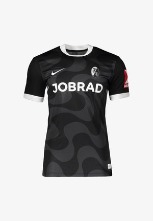 Czarna i ciemnoszara, falista wzorzysta koszulka piłkarska z białym kołnierzykiem i mankietami, logo sponsora "JOBRAD", symbol Nike oraz herb SC Freiburg.