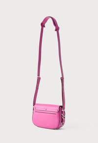 Růžová kožená crossbody taška s klopou, nastavitelným popruhem a stříbrnými akcenty. Obsahuje přední kapsu na skládání a hladký povrch.