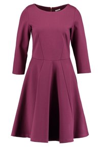 Robe violette mi-longue jusqu'aux genoux, manches trois-quarts, taille cintrée, encolure ronde et jupe évasée.