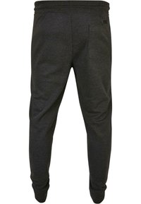 Donkergrijze joggingsbroek, gemaakt van zacht materiaal, met een elastische tailleband en een achterzak. Tapere ontwerp bij de enkels voor een strakke look.