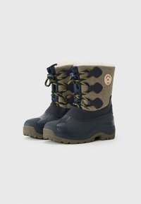 Botas de invierno con suelas y punteras de goma, sección inferior de color azul oscuro, parte superior de tela caqui, cordones amarillos y negros, y forro de felpa visible en la parte superior.