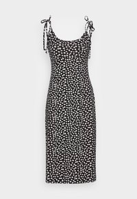 Svart klänning med vitt blommönster, justerbara knytband, figurnära design, knälängd och slät tygkvalitet.