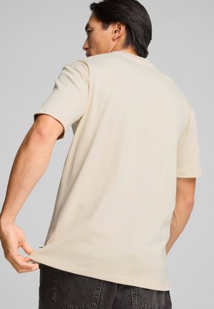 T-shirt beige in cotone con maniche corte, scollatura tonda e vestibilità comoda. Design semplice senza motivi o accenti visibili.